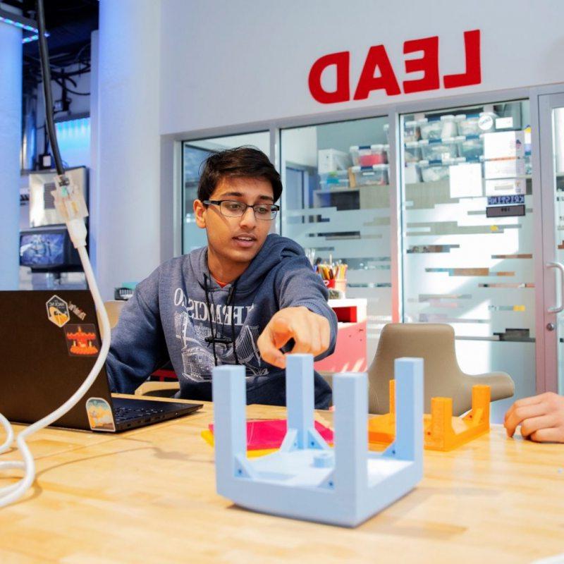 QUVI创始人Kush Jain(右)和Harshul Makwana(左)正在为北卡大学马拉松制作他们最初的水瓶卫生原型.
